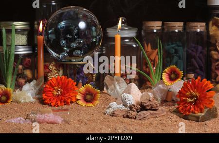 Boule de cristal avec bougies et pierres de chakra sur le sable rouge australien Banque D'Images