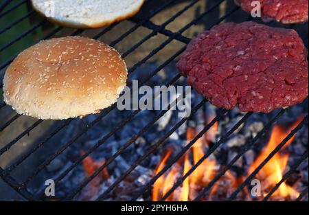 Les burgers de viande et petits pains pour hamburger sur fire grill Banque D'Images