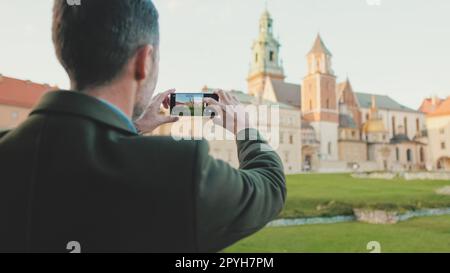 Man prend des photos sur son téléphone portable dans la vieille ville. Vue arrière Banque D'Images