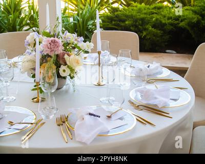 Table à la réception de mariage de luxe. Belles fleurs sur la table et plats et verres de service et décoration Banque D'Images