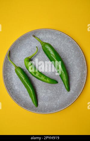 Piments verts de Cayenne sur un fond Uni Banque D'Images