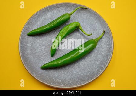 Piments verts de Cayenne sur un fond Uni Banque D'Images