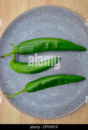 Piments verts de Cayenne sur un fond Uni Banque D'Images