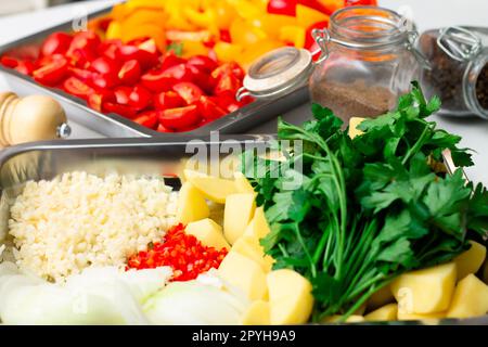 Ingrédients hachés pour préparer des ragoûts de légumes orientaux. Paprika, pommes de terre, oignons, tomates, ail, poivrons, épices. Banque D'Images