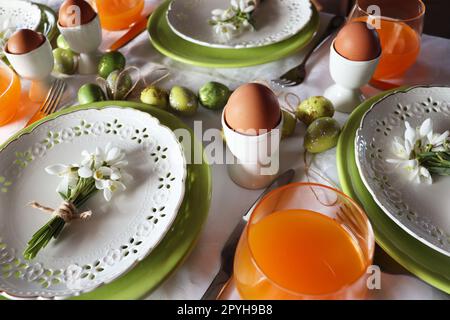 Table de Pâques élégante. Œuf naturel , gouttes de neige , assiette moderne, couverts. Décoration moderne de table de Pâques Banque D'Images