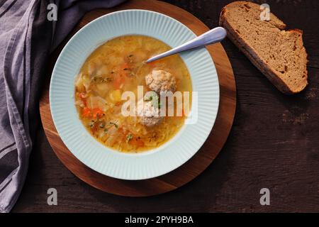 Soupe avec boulettes de viande sur fond sombre, serviette en lin gris. Soupe de boulettes de viande saine avec légumes. Vue de dessus Banque D'Images