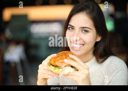 Femme heureuse prête à manger burguer dans un restaurant Banque D'Images