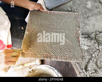 Gros plan installation du sol en tuiles dans les travaux de construction Banque D'Images