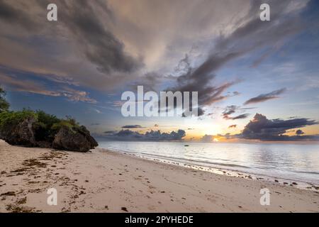 Cette photo à couper le souffle capture la beauté d'un lever de soleil sur la plage de Diani au Kenya. Les teintes orange et jaune vives des rayons du soleil illuminent le Banque D'Images