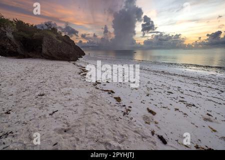 Cette photo à couper le souffle capture la beauté d'un lever de soleil sur la plage de Diani au Kenya. Les teintes orange et jaune vives des rayons du soleil illuminent le Banque D'Images