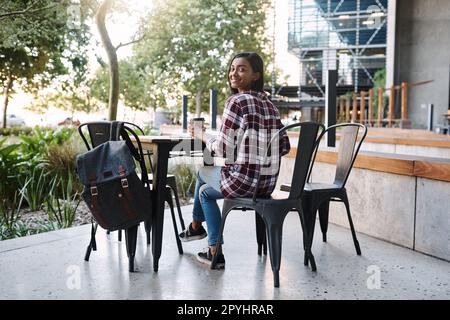 Si la messagerie instantanée n'est pas en classe, alors la messagerie instantanée est très probable ici. Portrait d'une jeune étudiante attrayante étudiant à une table à l'extérieur du campus. Banque D'Images