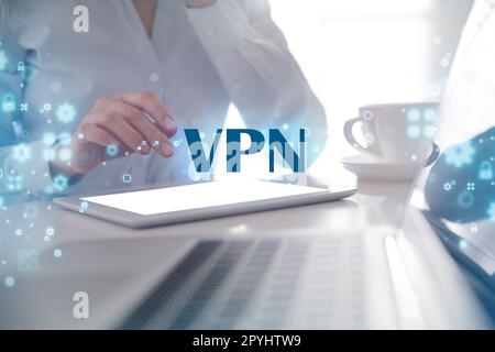 Femme utilisant une tablette moderne avec VPN activé au bureau, en gros plan Banque D'Images