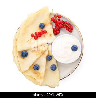 Délicieuses crêpes au yaourt naturel, aux myrtilles et aux raisins de Corinthe rouges sur fond blanc Banque D'Images