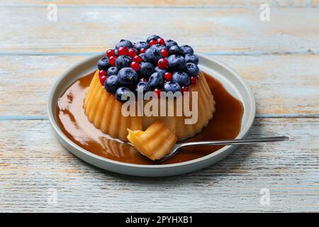 Délicieux pudding au caramel, aux myrtilles et aux groseilles sur une table en bois Banque D'Images