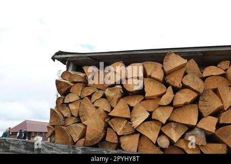 Pile de bois de chauffage haché sous le toit à l'extérieur Banque D'Images