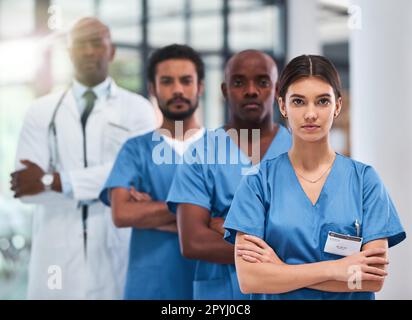 Ne craignez jamais, les médecins sont ici. Portrait d'un groupe de jeunes médecins confiants debout avec leurs bras repliés à l'intérieur d'un hôpital pendant la journée. Banque D'Images
