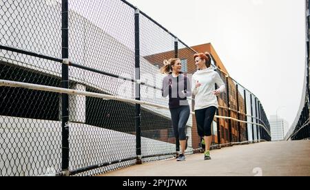 Les derniers miles. Prise de vue en longueur de deux jeunes femmes attrayantes qui traversent la ville. Banque D'Images