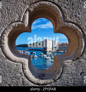 Le vieux port de Dubrovnik vu à travers une rosace dans le mur Banque D'Images