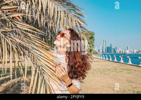 Elle se prélase au soleil du parc d'Abu Dhabi, entouré par les imposants bâtiments du centre-ville et la verdure verdoyante de la Banque D'Images