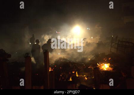 Les pompiers qui effectuent la phase de refroidissement après un accident d'incendie ont brûlé des centaines de maisons dans un quartier dense de Penjaringan, dans le nord de Jakarta, Jakarta, Indonésie. Une phase de refroidissement est lancée lorsque l'incendie dans toute la zone d'incendie-accident est déjà éteint, contrôlé, ou lorsque rien n'est laissé à l'état de sauvegarde, un agent a expliqué à une autre occasion. Lors du refroidissement, 2-3 agents se promèneront entre les ruines et les débris selon certains modèles pour refroidir les flammes, les fumées, et pour nettoyer et sécuriser les substances combustibles dangereuses, « pour s'assurer qu'un nouvel incendie ne se déclenchera pas et ne se propagera pas à nouveau ». Banque D'Images