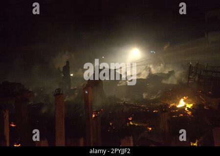 Les pompiers qui effectuent la phase de refroidissement après un accident d'incendie ont brûlé des centaines de maisons dans un quartier dense de Penjaringan, dans le nord de Jakarta, Jakarta, Indonésie. Une phase de refroidissement est lancée lorsque l'incendie dans toute la zone d'incendie-accident est déjà éteint, contrôlé, ou lorsque rien n'est laissé à l'état de sauvegarde, un agent a expliqué à une autre occasion. Lors du refroidissement, 2-3 agents se promèneront entre les ruines et les débris selon certains modèles pour refroidir les flammes, les fumées, et pour nettoyer et sécuriser les substances combustibles dangereuses, « pour s'assurer qu'un nouvel incendie ne se déclenchera pas et ne se propagera pas à nouveau ». Banque D'Images