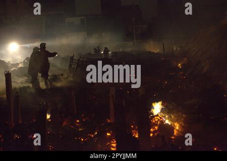 Les pompiers qui effectuent la phase de refroidissement après un accident d'incendie ont brûlé des centaines de maisons dans un quartier dense de Penjaringan, dans le nord de Jakarta, Jakarta, Indonésie. Une phase de refroidissement est lancée lorsque l'incendie dans toute la zone d'incendie-accident est déjà éteint, contrôlé, ou lorsque rien n'est laissé à l'état de sauvegarde, un agent a expliqué à une autre occasion. Lors du refroidissement, 2-3 agents se promèneront entre les ruines et les débris selon certains modèles pour refroidir les flammes, les fumées, et pour nettoyer et sécuriser les substances combustibles dangereuses, « pour s'assurer qu'un nouvel incendie ne se déclenchera pas et ne se propagera pas à nouveau ». Banque D'Images