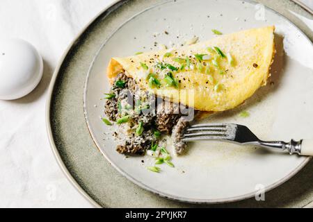 Omelette aux morilles et au fromage dans une sauce crémeuse. Banque D'Images