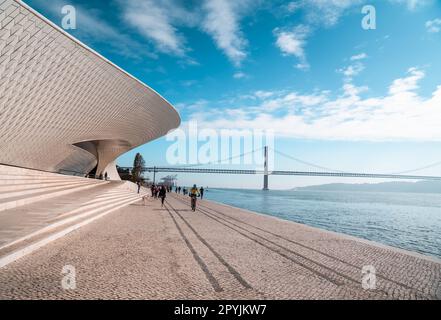 Un groupe de personnes se promenant tranquillement le long du front de mer à Lisbonne, Portugal Banque D'Images