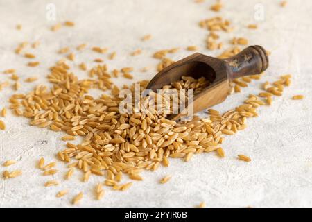 Cuillère en bois de grain de seigle cru sec sur la table blanche en gros plan Banque D'Images