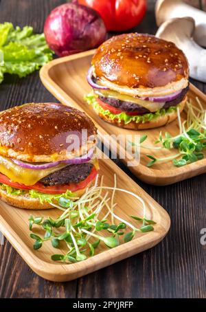 Hamburgers sur les assiettes en bois Banque D'Images