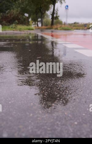 Plan vertical de gouttes de pluie tombant sur le sol dans les rues d'Allemagne Banque D'Images