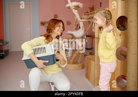 Femme souriante montrant le chat dans la cage à peu peur petite fille mignon enfant Banque D'Images