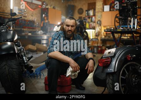 Homme mûr barbu moto de nettoyage dans le poste de travail de garage Banque D'Images