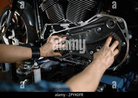 Homme mécanicien de réparer le moteur de moto travaillant dans un atelier de garage Banque D'Images