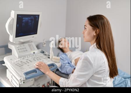 Focus sélectif médecin faisant l'échographie du fœtus à la femme enceinte Banque D'Images