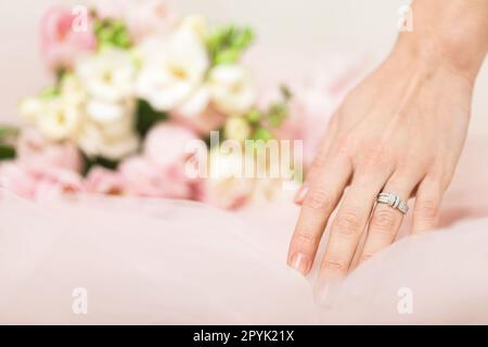 main de mariée avec une bague de mariage sur le fond de fleurs Banque D'Images