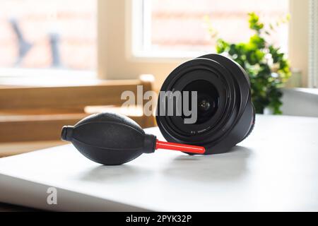 Objectif sur bureau avec outils de nettoyage pour reflex numériques et appareils photo sans miroir. Kit de nettoyage pour surface cmos. Souffleur d'air, écouvillon, compte-gouttes à l'alcool isopropylique et chiffons microfyber. Solution de nettoyage des objectifs et des appareils photo pour les professionnels. Banque D'Images