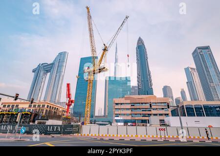 17 janvier 2023, Dubaï, Émirats arabes Unis : travailleurs de casques sur un chantier de construction avec des machines de grue Banque D'Images