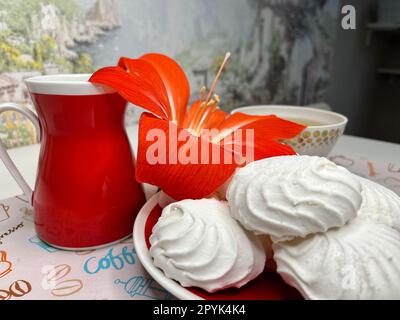 quelques guimauves sur une soucoupe et une tasse de thé parfumé Banque D'Images