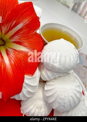 quelques guimauves sur une soucoupe et une tasse de thé parfumé Banque D'Images