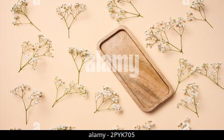 Assiette en bois carrée vide sur fond beige, vue de dessus Banque D'Images