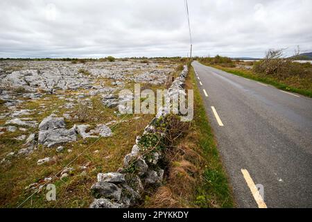 petite route de campagne avec mur de pierre sèche frontière de terre à travers le comté de burren clare république d'irlande Banque D'Images