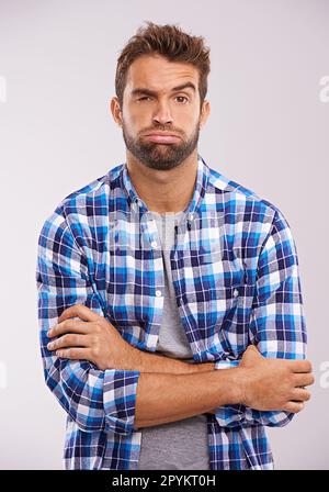 Frustré, fatigué et portrait d'un homme avec les bras croisés dans un studio sentiment ennuyé et ennuyé. Isolé, fond blanc et modèle mâle avec contrarié Banque D'Images