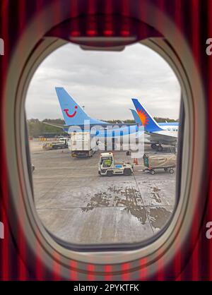 Vue fenêtre d'un avion de location de vacances Jet2, Tui Holiday et d'autres charter ayant des bagages de soute chargés Banque D'Images