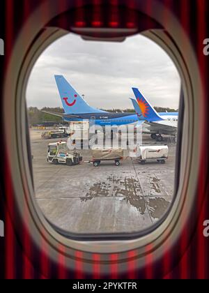 Vue fenêtre d'un avion de location de vacances Jet2, Tui Holiday et d'autres charter ayant des bagages de soute chargés Banque D'Images