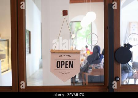 L'affiche du magasin indiquant qu'elle est ouverte, l'affiche du restaurant ouvert frappe sur la porte vitrée. Banque D'Images