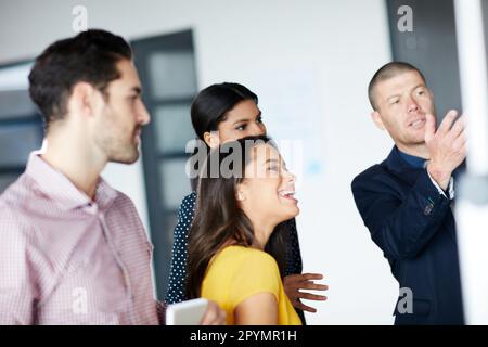 Travailler sur la prochaine grande chose. quatre hommes d'affaires travaillant au bureau. Banque D'Images