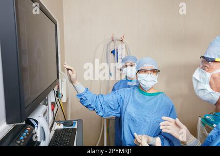 Experts dans le domaine anatomique. une équipe de chirurgiens discutant des examens médicaux d'un patient pendant la chirurgie. Banque D'Images