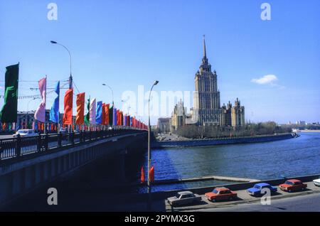 1988: Des drapeaux volent sur le pont Kutuzovsky au-dessus de la rivière Moskva en face de l'Hôtel Ukraina en préparation pour les célébrations du jour de mai. Le bâtiment baroque de style « gâteau de mariage » est l'une des soi-disant « Sœurs de la mariée » commandée par Joseph Staline dans le cadre d'un plan de modernisation de Moscou immédiatement après la Seconde Guerre mondiale La construction a commencé en 1953 et l'hôtel Ukraina a ouvert ses portes en 1957. Banque D'Images