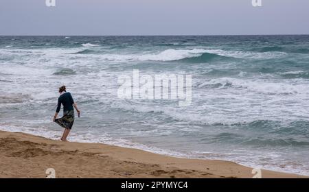 Personne non reconnue qui marche sur une plage de sable tropical. Activités de plein air. Vagues venteuses et orageuses. Protaras Chypre Banque D'Images